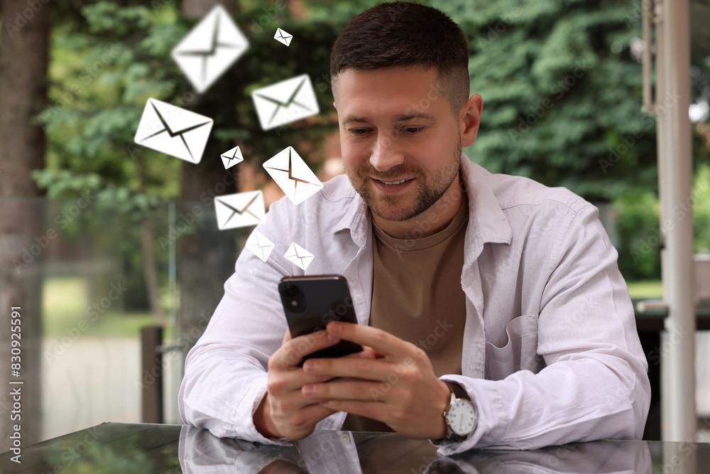 Wall mural smiling man with smartphone chatting outdoors. many illustrations of envelope as incoming messages o