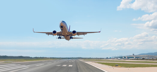 White Passenger plane fly up over take-off runway from airport - Barcelona, Spain