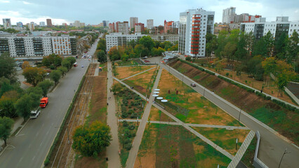 Top view of park alley in residential area of city. Clip. View of city with residential buildings...