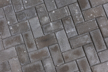 A pedestrian path on the street paved with cobblestones. Close-up view from above. Texture