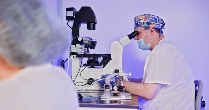 An embryologist conducts artificial fertilization of a human egg using advanced laboratory equipment. The image depicts precise IVF procedures.