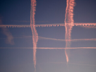 Estelas de avión cruzadas a la puesta de sol