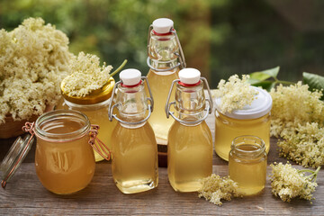Several bottles and jars of homemade elderberry flower syrup prepared in spring