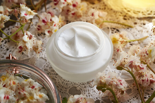 Homemade horse chestnut cream in a glass jar with freh Aesculus hippocastanum flowers