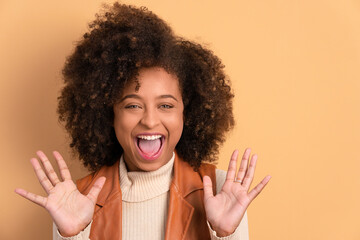 fun afro brazilian woman raising arms and celebrating in studio shot. portrait, real people concept.