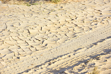 Cracked, parched earth showing the consequences of extreme drought, clods of earth bent open in drought, cracked earth surface, dry cracks in the ground. United Arab Emirates.