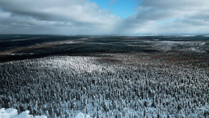 A flight over the dense winter Siberian forest in the afternoon. Clip. White mountain and a frozen...