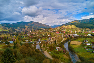Naklejka premium Aerial view amazing over Viaduct is an Austrian stone arch bridge in Vorokhta Ukraine. Cloudy autumn day in the the Carpathian Mountains