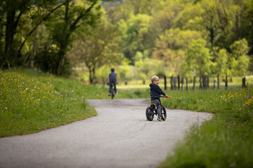 Fototapeta premium little blond cute boy riding his bike