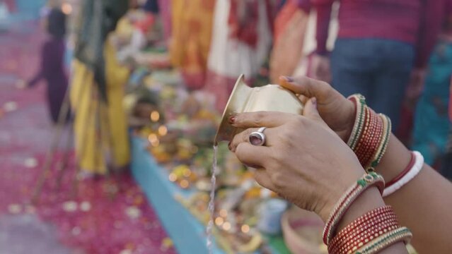 holy water offerings by indian devotee doing traditional rituals at chhath festival at morning