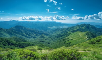 A picturesque mountain range rises majestically under clear blue skies, with green valleys stretching below. The expansive, open areas provide a stunning backdrop with space for overlaying text.