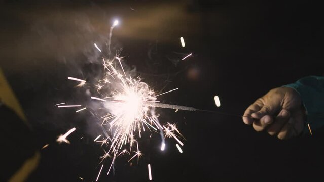 Pencil crackers or indian Phuljhadi fireworks holding in hand at Diwali festival celebration
