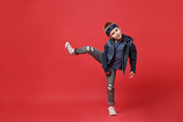 Happy little boy dancing on red background