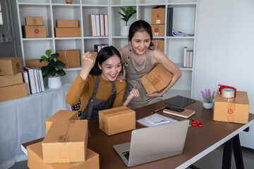 Happy female entrepreneurs celebrating online sales success in home office. Concept of small business, ecommerce, and teamwork