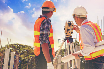Engineer or surveyor worker working with theodolite transit equipment at outdoors construction...