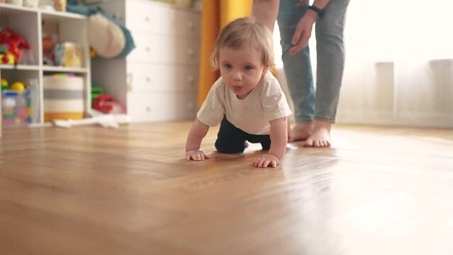 baby crawls. happy family a kid dream concept. baby crawls takes first steps to study indoors. mother teaches baby to crawl takes first steps. children lifestyle learning concept