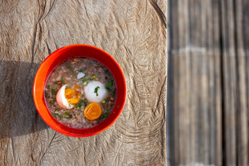 Selective focus Thai style minced pork porridge with boiled egg. Breakfast in an orange cup Helps increase energy