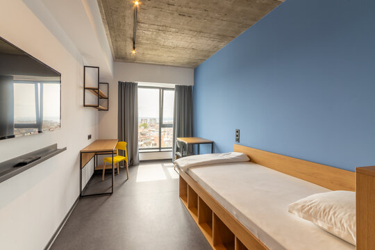 Simple student-style dorm bedroom. Hostel dormitory room. Campus