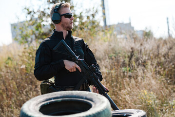 A man with a machine gun learns to shoot at a shooting range