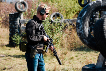 A guy with a machine gun learns to shoot at a shooting range