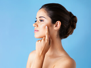 Profile, skincare and woman with dermatology, thinking and wellness on blue studio background....