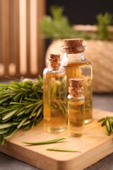 Essential oil in bottles and rosemary on table