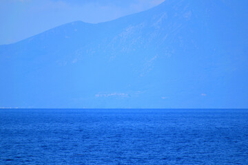 Obraz premium seascape with a cloudy mountain - mount Athos, Greece, aegean sea