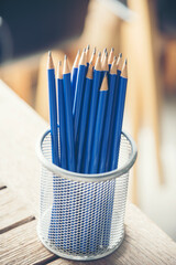 Vertical sharp HB pencil vase office supply decor on wood table. Green decorate home office desk....