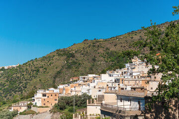 view of the houses of a village high up in the mountains with blue sky
