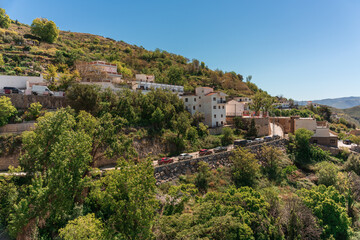 Obraz premium general view of a beautiful mountain village with its houses among trees and some cars parked on the road.