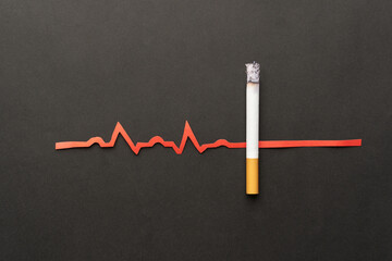 Cigarettes or tobacco with EKG on black background. Quit smoking and save your life. World no...