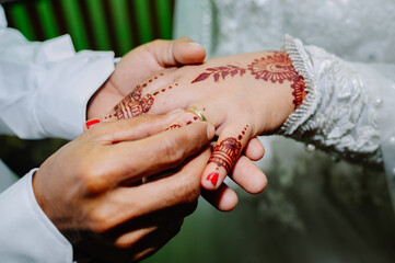the groom puts a wedding ring on the bride's ring finger as a sign that they are officially married...
