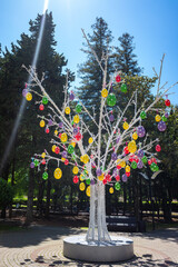 Easter tree, eggs hang on the tree against the blue sky.