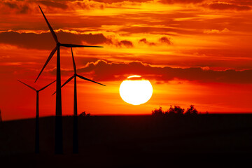 The setting sun behind wind turbines