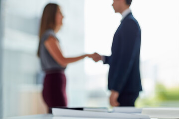 Shaking hands, man and woman in blurred office for interview, welcome or onboarding for collaboration. Partnership, business people and handshake in conference room for agreement, consulting or deal.