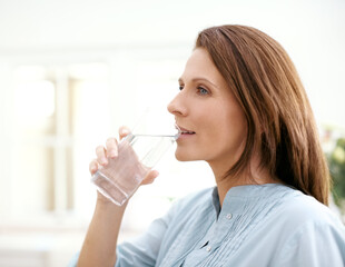Home, thinking and woman with drinking water in glass for hydration, minerals and liquid nutrition....