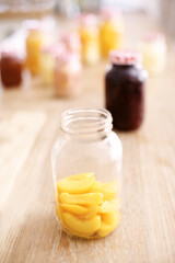 Open, jar and peach on table, kitchen and fruit for nutrition, healthy and glass on wood and protein. Home, countertop and preserved for diet, vitamin c and breakfast in morning, snack and food