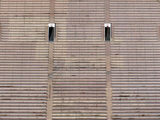 Aerial image of an empty concrete stadium with bench seating and two vomitorium, access tunnels.