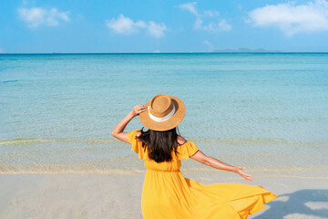 Rear View of young Asian female relax at the beach. Summer, travel and vacation concept. Copy space