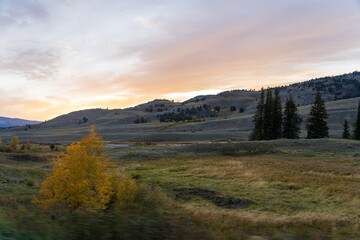 Sunset in the Lamar Valley in Yellowstone National Park in Montana and Wyoming on a beautiful fall evening. Sun sets over the mountains and sagebrush with a colorful sky illuminating the landscape.
