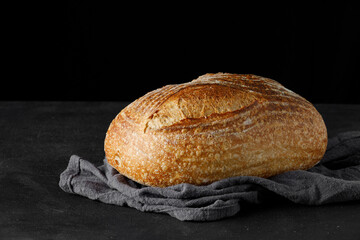 Traditional rustic sourdough bread on a towel. Baked artisan bread on table