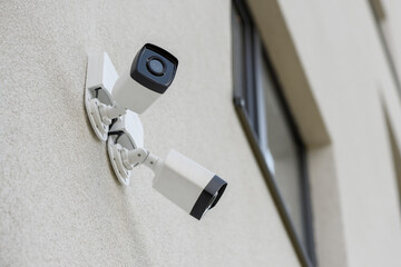 Two external city CCTV security cameras on the wall of the house. Safe and comfortable urban environment. Crime control and prevention. Street security, security. Improving the quality of city life.