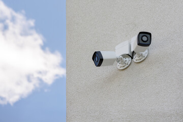 Two external city CCTV security cameras on the wall of the house. Safe and comfortable urban environment. Crime control and prevention. Street security, security. Improving the quality of city life.