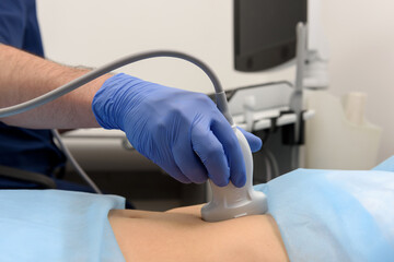 A doctor using an ultrasound transducer performs an ultrasound examination. Ultrasound scanner on a...