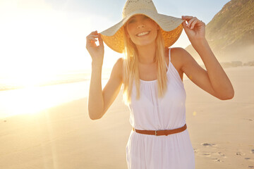 Sunset, portrait and happy woman for walk on beach with hat, travel and adventure in nature. Female...