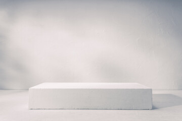 A clean, white platform set against a minimalist gray background, perfect for showcasing or presenting products in a professional studio setting.