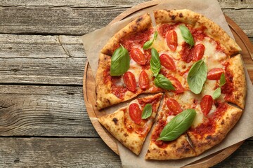 Delicious Margherita pizza on wooden table, top view. Space for text