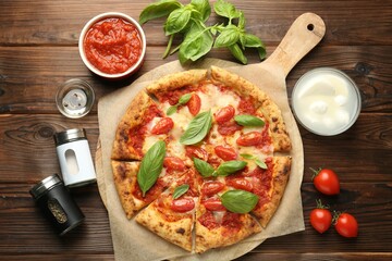 Delicious Margherita pizza and ingredients on wooden table, top view