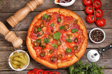 Delicious pizza Diablo, ingredients and cutter on wooden table, flat lay
