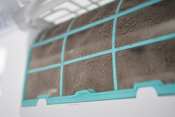Closeup of dirty dust air conditioner filter on wall. Home air conditioner maintenance. Dusty...